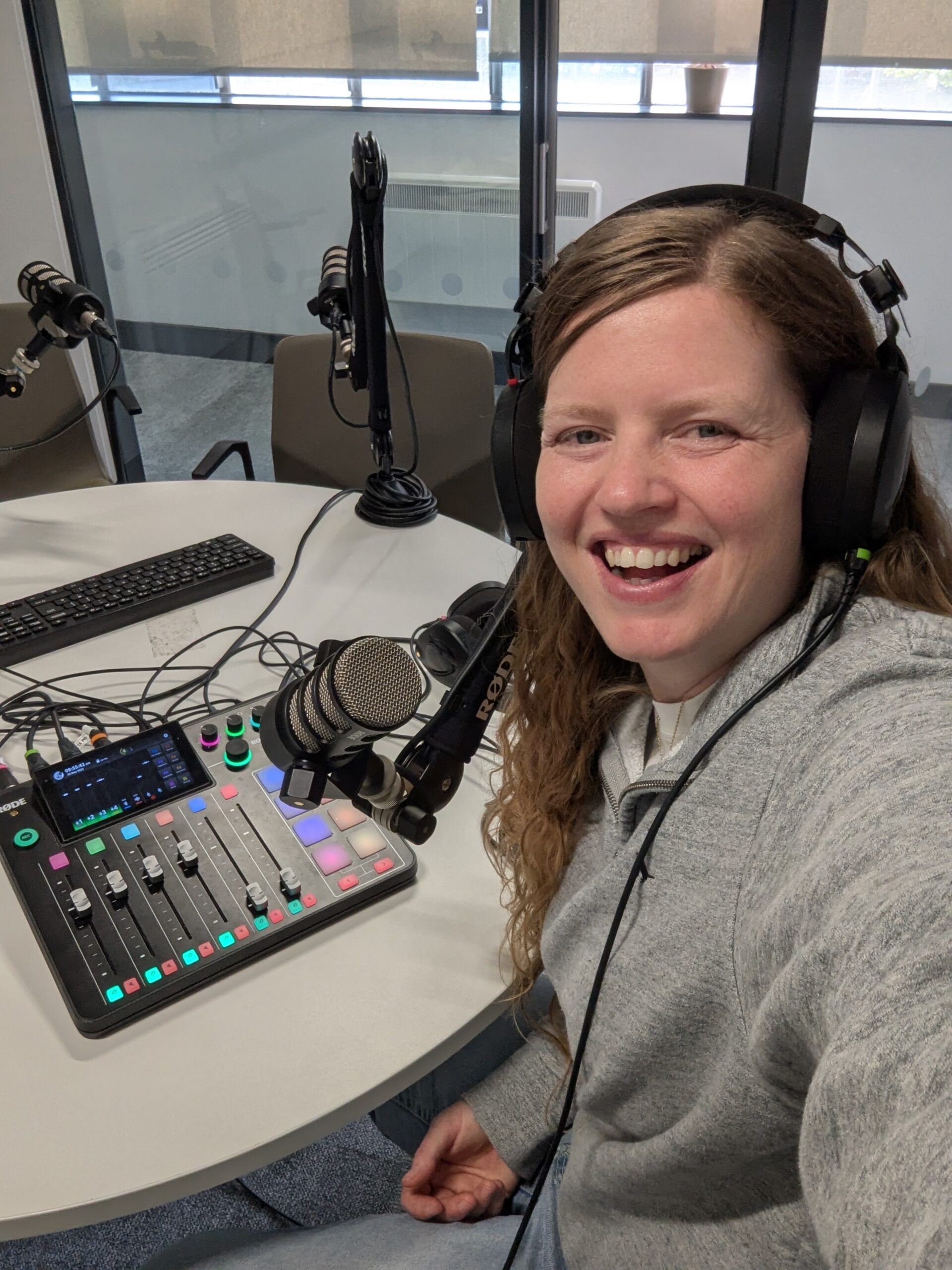 Krissie behind a mic recording a podcast